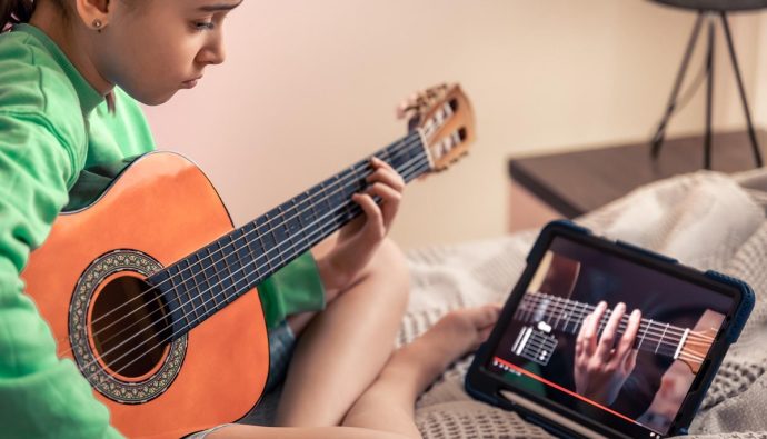dziewczynka uczy się gry na gitarze online