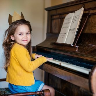 mała dziewczyna uczy się gry na pianinie