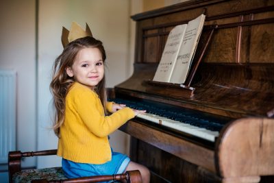 mała dziewczyna uczy się gry na pianinie
