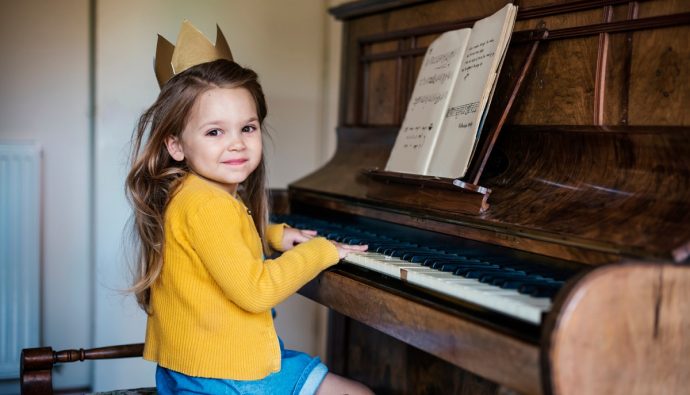 mała dziewczyna uczy się gry na pianinie