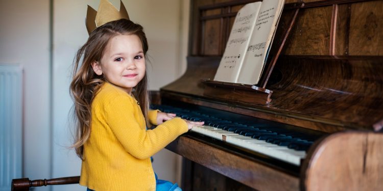 mała dziewczyna uczy się gry na pianinie